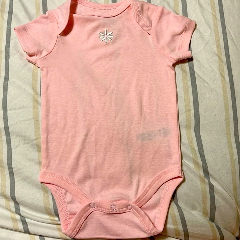 Little Me Pink Onesie with snaps has small flower on the chest.